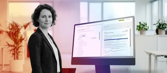 Woman in office showing financial software on a desktop computer.