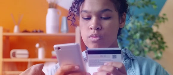 Customer entering credit card details on a smartphone to pay a utility bill