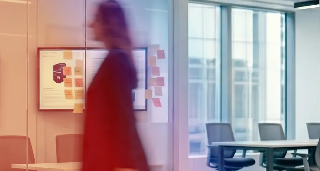 A fast-moving tech leader walks past a lean cross-functional team brainstorming on a whiteboard, representing efficient product strategy alignment for resource-constrained engineering teams.