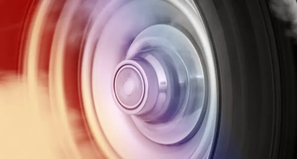 A high-speed motion blur of a spinning mechanical wheel with smoke accents, representing engineering team momentum and rapid software roadmap velocity.