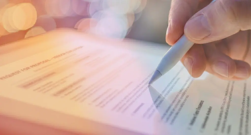 Close-up shot of a digital product architect using a white stylus pen on a tablet screen to review software code configurations and interface designs.